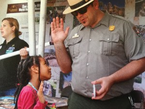 Ranger Jason Ginder inducting a new Jr. Ranger Chief of Interpretation & Education 